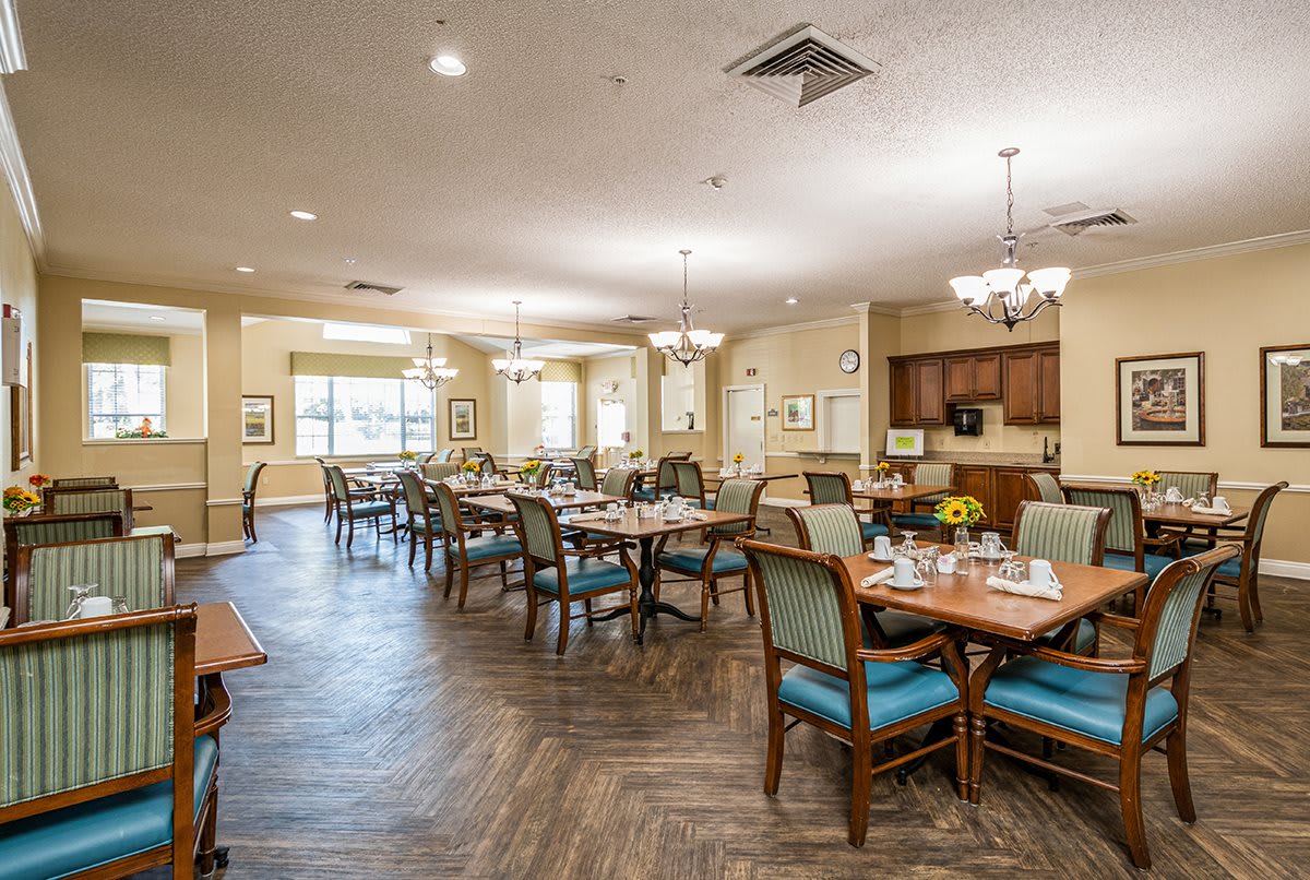 A spacious and well-lit dining area with neatly arranged tables and chairs.