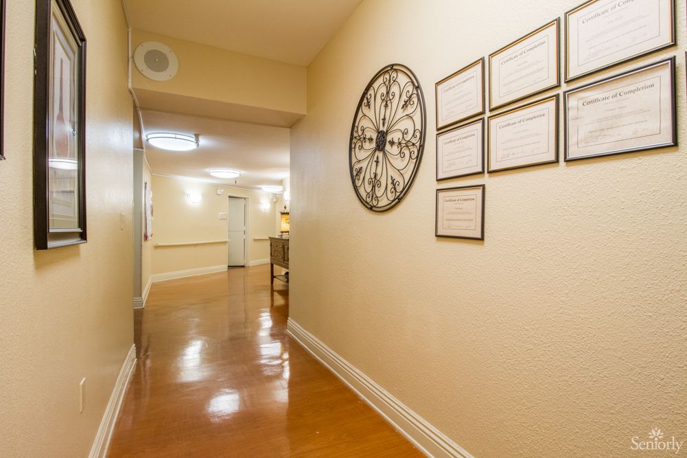 A well-lit hallway with decorative elements including a large wall clock and framed pictures.