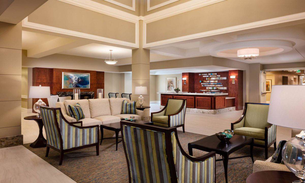 A spacious hotel lobby with comfortable seating and a reception desk.