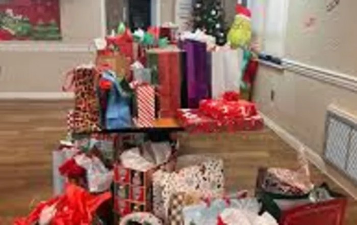 A festive scene with a large pile of Christmas presents and holiday decorations.