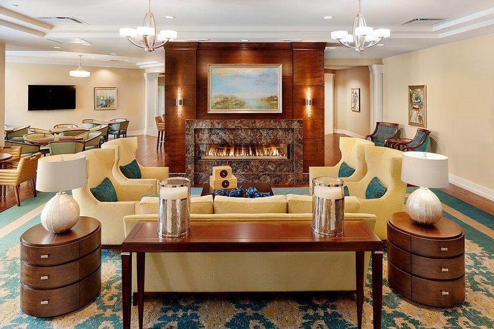 A cozy living room with elegant furniture, a central fireplace, and tasteful artwork.