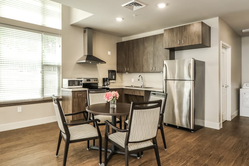 A modern kitchen with stainless steel appliances and a cozy dining area.