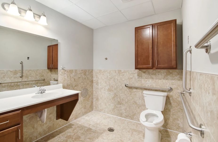 A clean, modern bathroom with a toilet, sink, and wall-mounted cabinet.