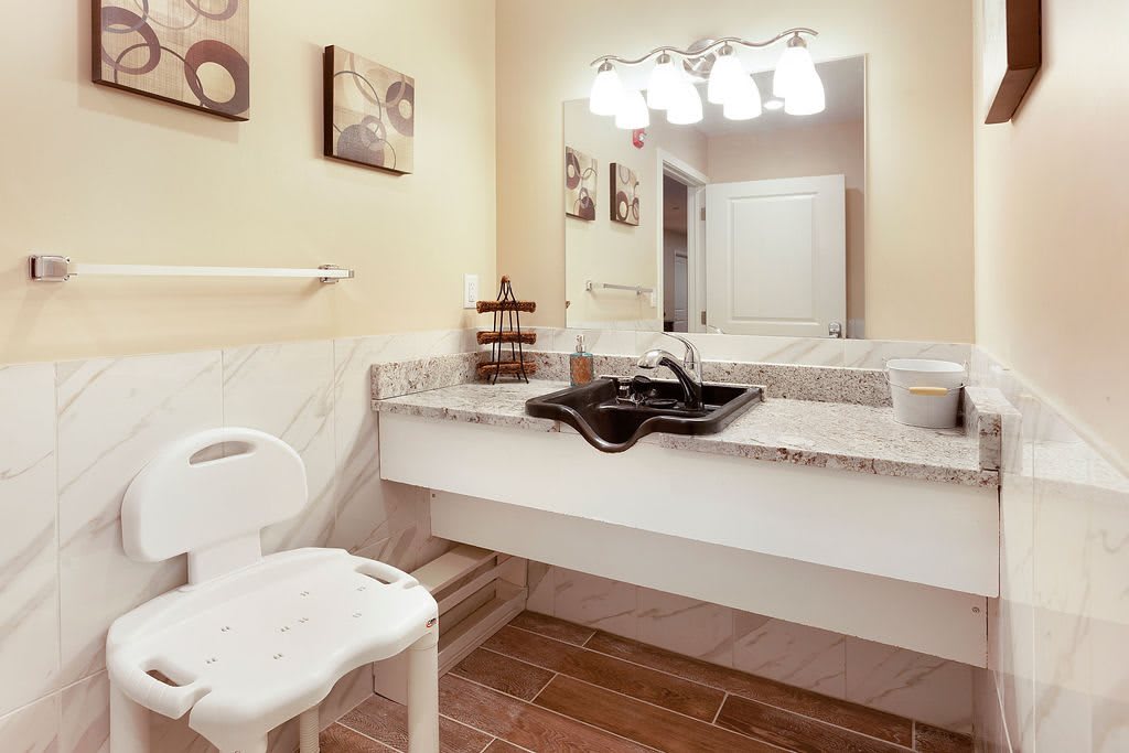 A well-lit bathroom featuring a sink with a large mirror and modern decor.