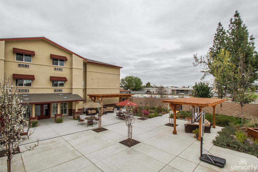 A courtyard with outdoor seating in front of a multi-story building on an overcast day.
