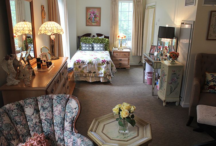 A cozy bedroom with vintage floral decor and traditional furnishings.
