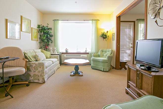 A cozy living room with light green accents and comfortable seating.