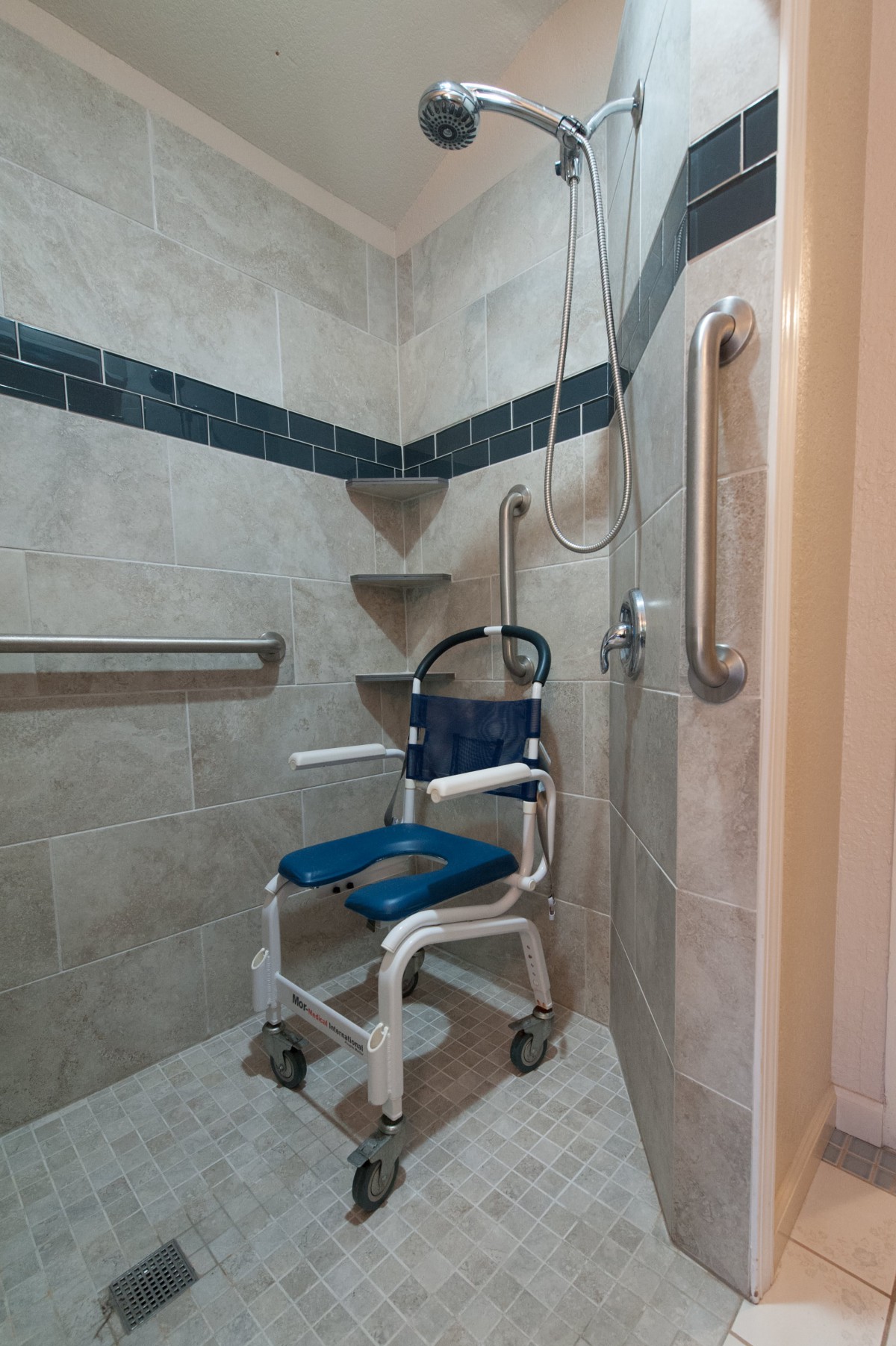 A wheelchair-accessible shower with grab bars and a specialized shower chair.