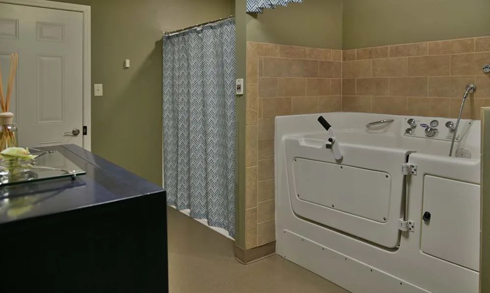 A bathroom featuring a walk-in bathtub and shower area with a curtain.