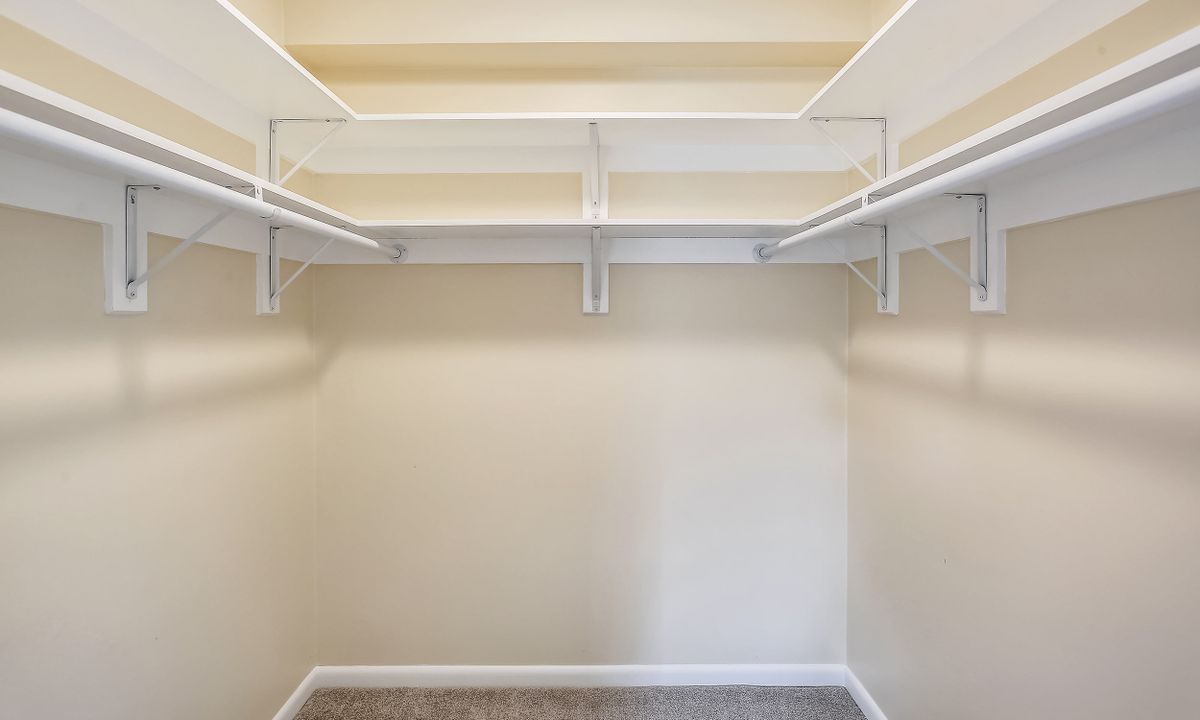 An empty walk-in closet with shelving units.