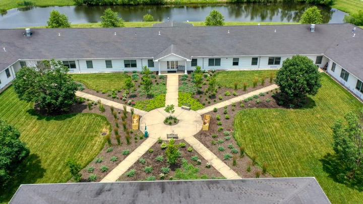 Aerial view of a building surrounded by landscaped gardens and pathways.