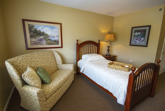 A cozy bedroom with a single bed and a patterned sofa.