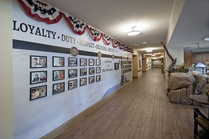 A hallway featuring a military tribute with photographs and patriotic decorations.