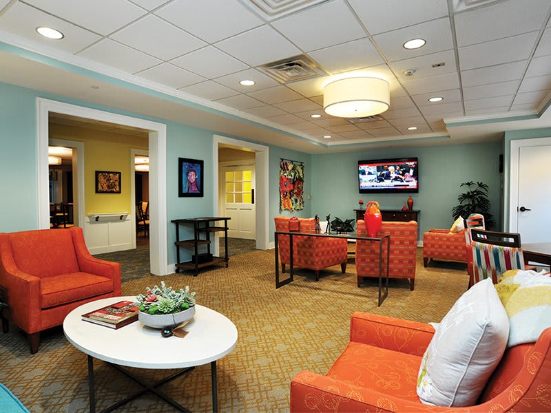 A modern waiting room featuring comfortable seating and a television.