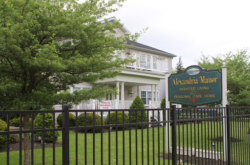 A well-kept residential house with a welcoming sign and lush green surroundings.