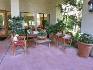A cozy outdoor patio with comfortable seating and lush greenery.