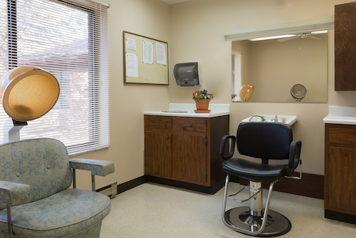 A view of a dentist's office featuring a waiting area and examination chair.