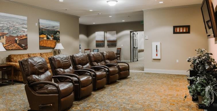 A cozy waiting room with leather recliners and carpeted flooring.