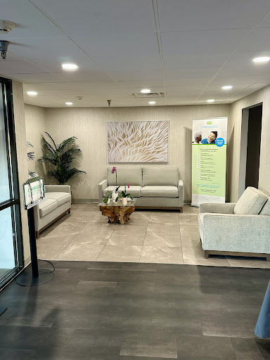 A modern and inviting lobby area featuring comfortable seating, decorative art, and greenery.