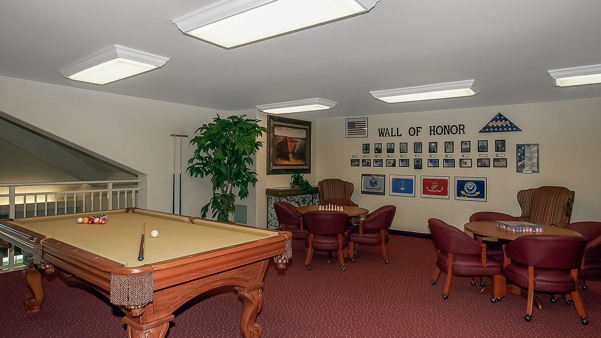 A meeting room featuring a pool table, chairs, and a 'Wall of Honor' display.