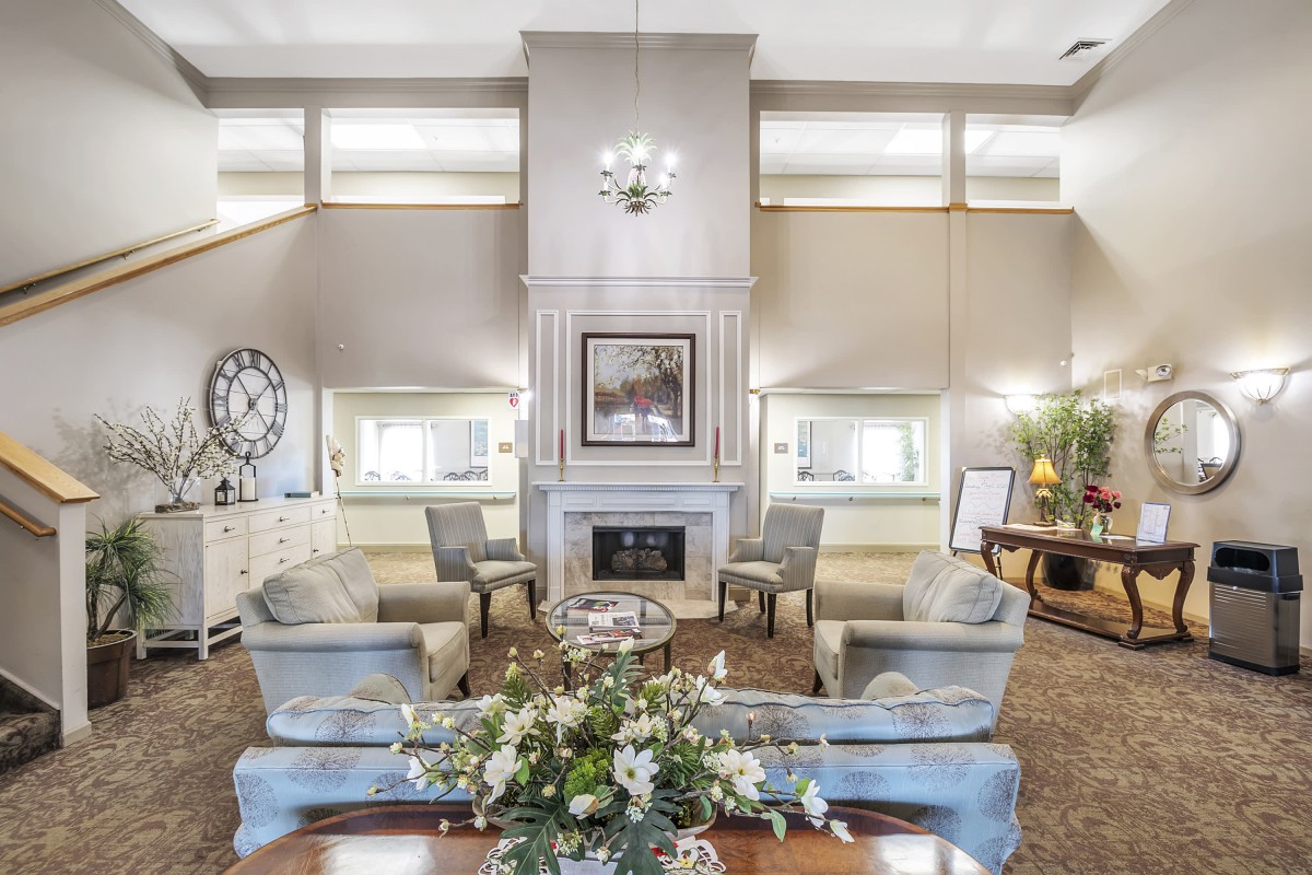 A luxurious living room featuring a central fireplace, elegant furnishings, and a chandelier.