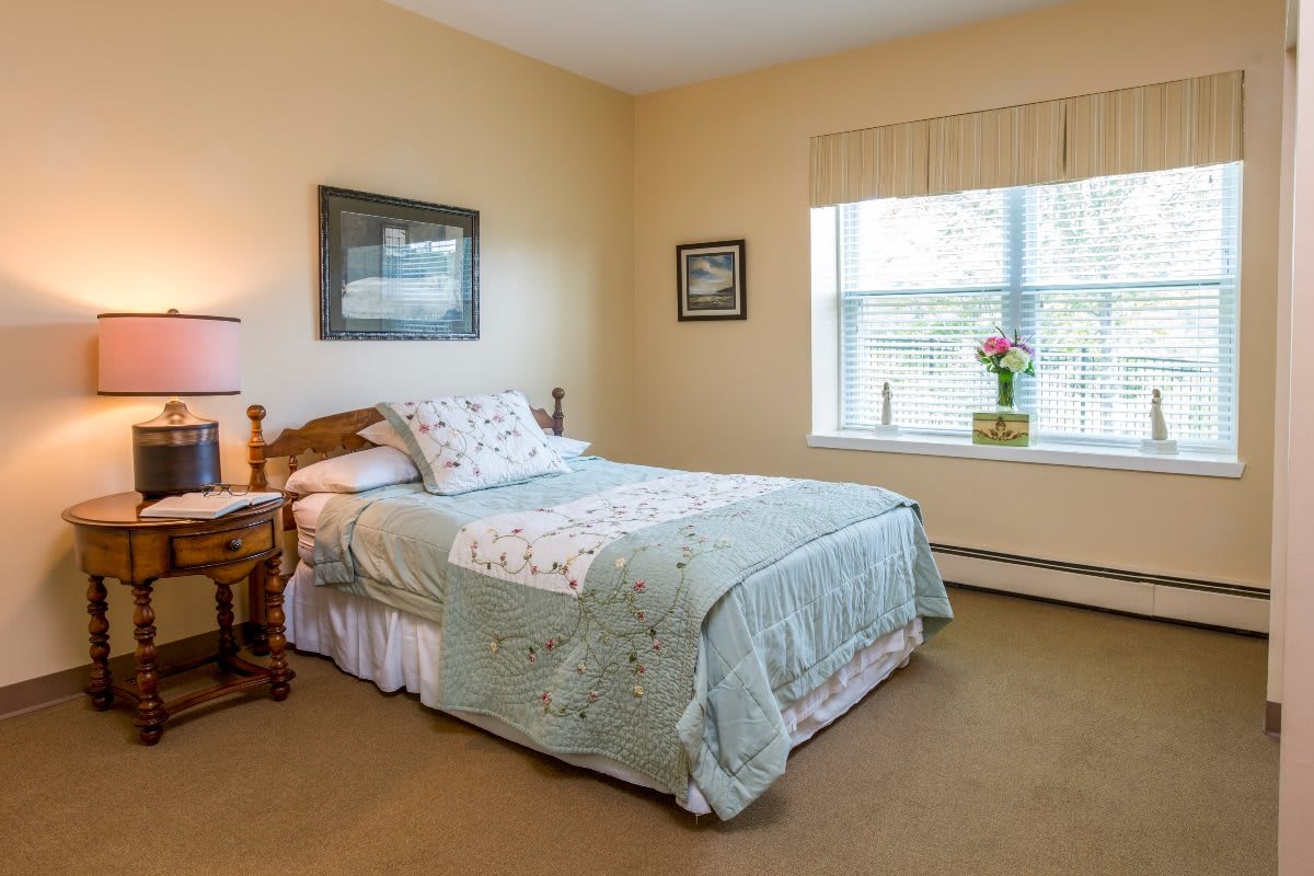 A cozy bedroom with a single bed, decorative pillows, and framed artwork on the walls.