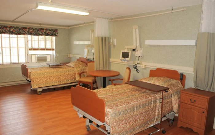 A hospital room with two beds and medical equipment.