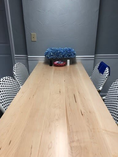 A long wooden dining table with patterned chairs and a decorative centerpiece in a modern dining room.