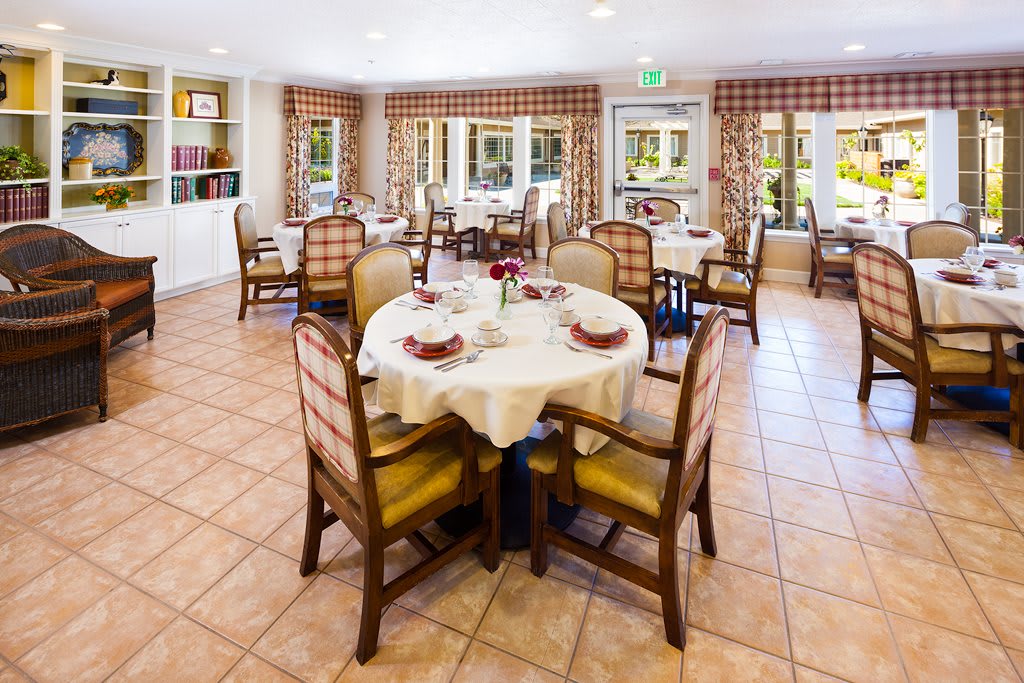 A bright and inviting dining area with elegantly set tables and comfortable chairs.