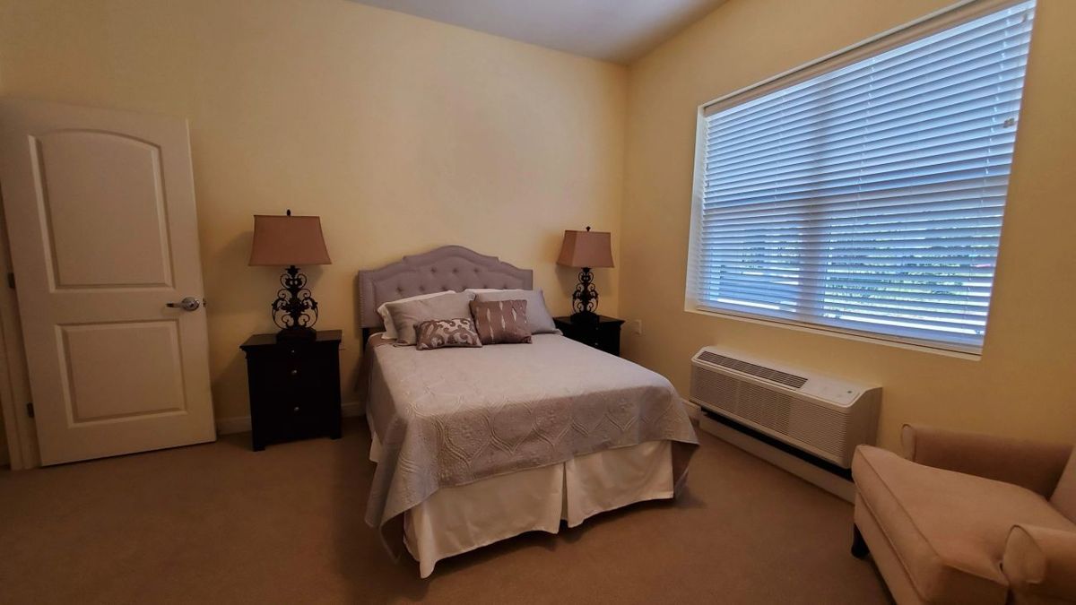 A cozy bedroom with a neatly made bed and side lamps.