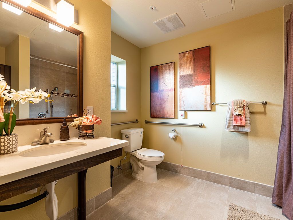 A well-lit bathroom interior featuring modern decor and artwork.