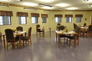 An empty dining room with several tables and chairs arranged neatly.