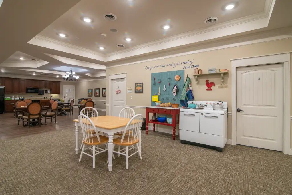 A cozy indoor room with a play area featuring a table and chairs, a kitchen set, and various decorations.
