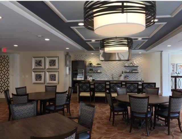 A modern dining area with elegant lighting and neatly arranged tables and chairs.