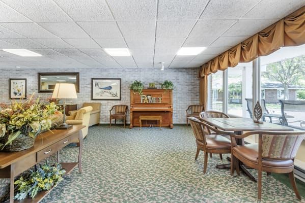 A cozy lounge area with a piano, seating arrangements, and decorative elements.