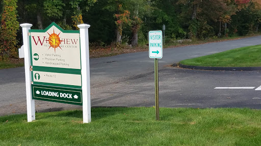 A directional sign on a roadside leading to a dock area.