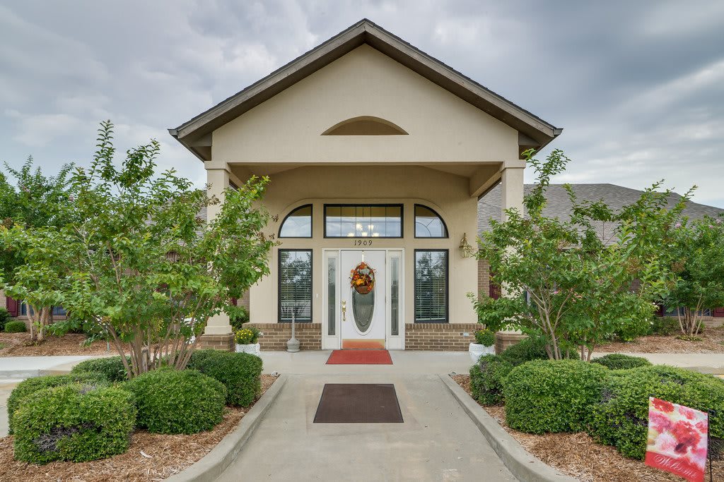 A symmetrical building entrance with landscaped greenery and a welcoming pathway.