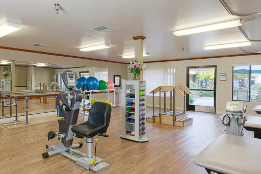 A well-equipped fitness center featuring exercise machines, stability balls, and an inviting atmosphere for rehabilitation and wellness.