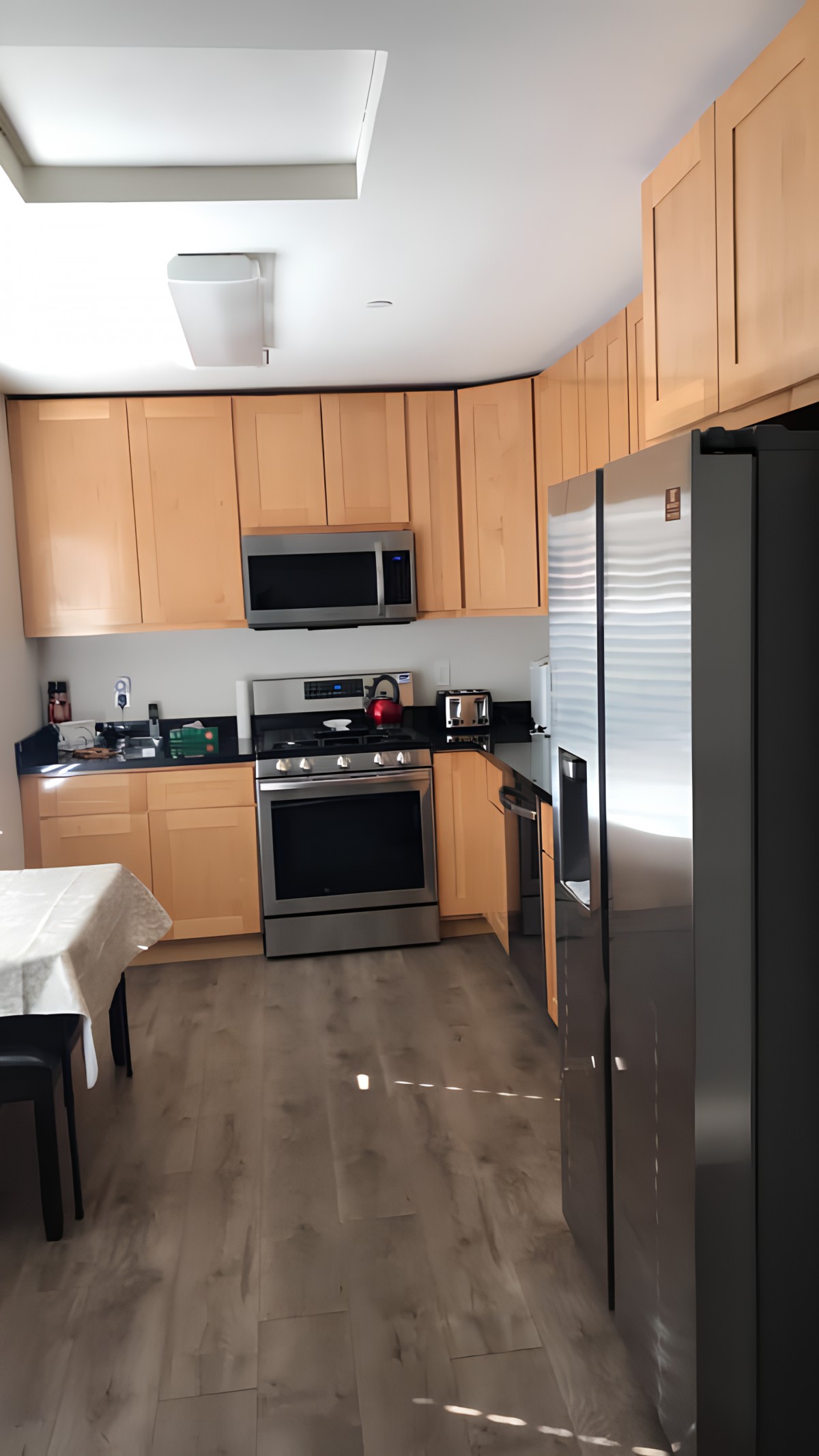 A modern kitchen with wooden cabinets and stainless steel appliances.