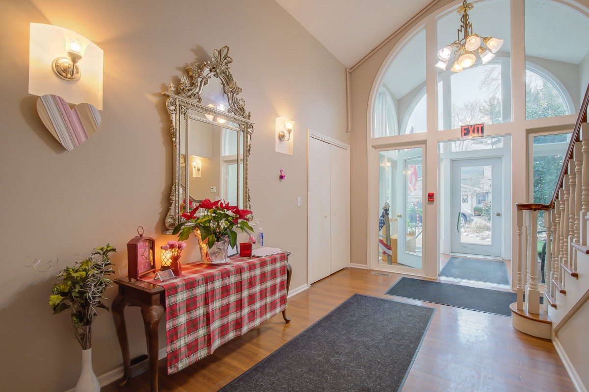 A welcoming entrance area with a decorated table, mirror, and checkered tablecloth.