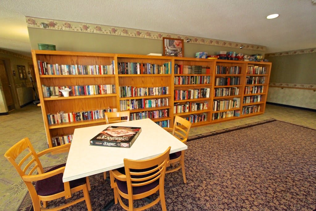 A cozy library corner with bookshelves and a reading table.