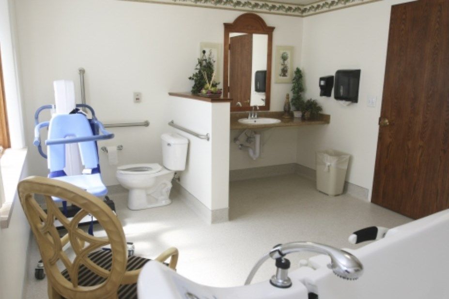 An accessible and well-organized bathroom with a toilet, sink, and handrails.