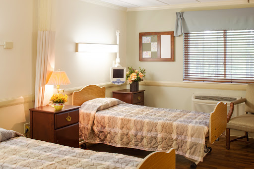 A cozy hospital room with two beds, soft lighting, and a warm atmosphere.