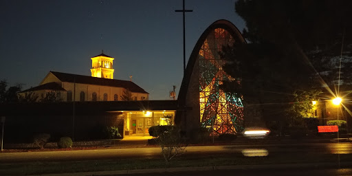 A beautifully illuminated church at night, featuring unique architectural elements and vibrant stained glass.