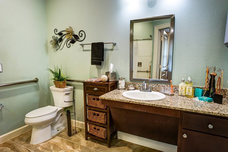 A well-decorated bathroom featuring a sink with a large mirror, a wooden cabinet, and various decorative elements.