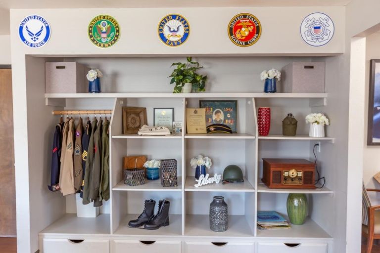 A neatly organized display of military memorabilia and uniforms on shelves.
