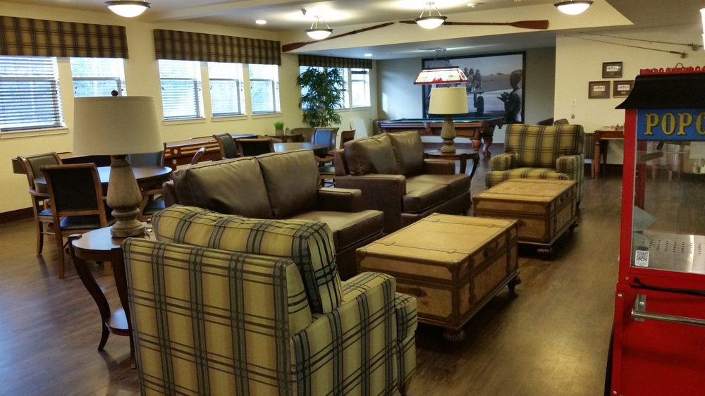 A cozy living room with sofas, plaid chairs, and wooden coffee tables.