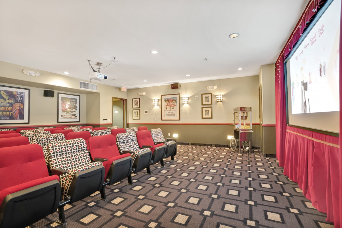 A cozy home theater room with red seating and classic cinema decor.