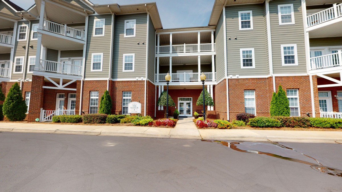 A modern apartment building with a well-maintained entrance and landscaping.
