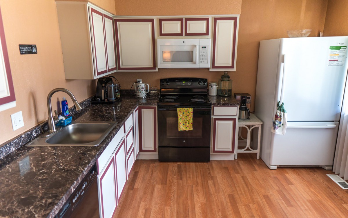 A cozy kitchen with modern appliances and wooden cabinets.